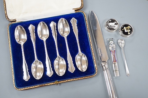 A cased set of six silver teaspoons, a silver bread knife, two 925 pill boxes, an 800 and enamel 'Tutankhamun' pencil case and a silver condiment spoon.